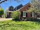 Charming two-story brick home with manicured lawn, blooming tree and dormer windows at 7079 S Locust Pl, Centennial, CO 80112