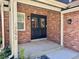 Inviting front entrance featuring a brick facade, black double doors, and modern light fixtures at 7079 S Locust Pl, Centennial, CO 80112