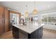 Open kitchen with stainless steel appliances, large island with seating, and ample natural light at 7079 S Locust Pl, Centennial, CO 80112