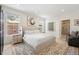 Bright main bedroom featuring neutral decor, a sitting area, and an ensuite bathroom at 7079 S Locust Pl, Centennial, CO 80112