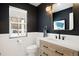 Modern powder room with dark walls, white vanity and gold accents at 7079 S Locust Pl, Centennial, CO 80112