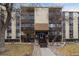 Multi-story building with balconies, beige siding, and well-maintained landscaping at 6930 E Girard Ave # 106, Denver, CO 80224