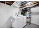 Unfinished basement laundry area with washer and dryer hookups and storage at 4827 Meade St, Denver, CO 80221