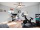 Bright home gym with a Peloton bike and workspace featuring dual monitors and a ceiling fan at 4827 Meade St, Denver, CO 80221