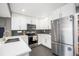 Modern kitchen with white cabinets, stainless steel appliances and sleek countertops at 4827 Meade St, Denver, CO 80221
