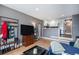 Open-concept living room with hardwood floors, modern decor, and a partial view of the adjacent kitchen at 4827 Meade St, Denver, CO 80221