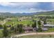 Expansive aerial view of the property, showcasing its location amidst rolling hills and trees, with views of the mountains at 24030 San Isabel Rd, Indian Hills, CO 80454