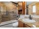 Well-lit bathroom with wood-look tile, modern fixtures, and a granite vanity at 24030 San Isabel Rd, Indian Hills, CO 80454