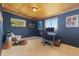 Comfortable bedroom with wood ceiling, two windows, and a cozy sitting area at 24030 San Isabel Rd, Indian Hills, CO 80454