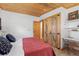 Bedroom featuring barn door closets, rustic décor, and plenty of natural light at 24030 San Isabel Rd, Indian Hills, CO 80454