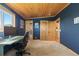 Comfortable bedroom with blue accent wall, wood ceiling, and natural light at 24030 San Isabel Rd, Indian Hills, CO 80454