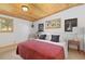 Cozy bedroom with wood ceiling, a comfortable bed, and large windows at 24030 San Isabel Rd, Indian Hills, CO 80454