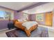 Bright bedroom with wooden trim windows, a cozy bed, and a blue accent rug at 24030 San Isabel Rd, Indian Hills, CO 80454