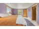 Bright bedroom with wooden trim windows, a cozy bed, and a blue accent rug at 24030 San Isabel Rd, Indian Hills, CO 80454