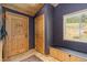 Home entryway featuring a wooden door, tiled floors, and a bench with storage at 24030 San Isabel Rd, Indian Hills, CO 80454