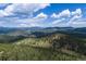Scenic aerial landscape shot of mountain range covered in dense green trees at 24030 San Isabel Rd, Indian Hills, CO 80454