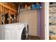 Unfinished basement laundry room offers washer, dryer, and wire shelving for supplies at 24030 San Isabel Rd, Indian Hills, CO 80454