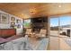 Cozy living room featuring a stone fireplace, hardwood floors, and access to an outdoor deck at 24030 San Isabel Rd, Indian Hills, CO 80454