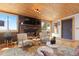 Comfortable living space with a fireplace, wood ceiling and access to an outdoor hot tub at 24030 San Isabel Rd, Indian Hills, CO 80454