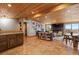 Open living room with hardwood floors, stone fireplace, wood ceiling, and beautiful mountain views at 24030 San Isabel Rd, Indian Hills, CO 80454