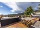 Relaxing outdoor deck features an outdoor table, sectional seating and mountain views at 24030 San Isabel Rd, Indian Hills, CO 80454