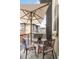 Cozy balcony featuring an umbrella-covered table and chairs, perfect for enjoying the outdoors at 181 S Monaco Pkwy, Denver, CO 80224