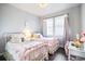 Charming bedroom with two twin beds, hardwood floors, and a bright window illuminating the space at 181 S Monaco Pkwy, Denver, CO 80224