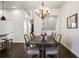 Elegant dining room with a large wooden table, chandelier, and seating for eight at 181 S Monaco Pkwy, Denver, CO 80224