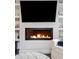 Comfortable living room showcasing a contemporary fireplace and built-in shelving for a relaxing atmosphere at 181 S Monaco Pkwy, Denver, CO 80224