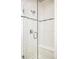 Elegant glass shower featuring white subway tile, decorative accent stripe, and convenient built-in bench at 181 S Monaco Pkwy, Denver, CO 80224