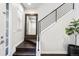 Modern staircase with dark wood steps, sleek black railing, and a large framed mirror at landing at 181 S Monaco Pkwy, Denver, CO 80224