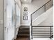 Modern staircase featuring dark wood steps, white risers, and black metal railings at 181 S Monaco Pkwy, Denver, CO 80224