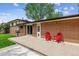Outdoor patio features two red Adirondack chairs and a grill, perfect for outdoor entertaining at 2990 S Jay St, Denver, CO 80227