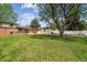 A large backyard with a well-kept lawn, mature trees, a storage shed, and a red brick house at 2990 S Jay St, Denver, CO 80227