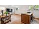 Spacious basement area featuring neutral carpet, large windows, and a wooden desk at 2990 S Jay St, Denver, CO 80227