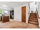 Finished basement with carpet flooring, a desk, bookshelves, and a staircase leading to the upper level at 2990 S Jay St, Denver, CO 80227