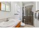 Modern bathroom with a glass-enclosed shower, vanity, and white cabinets at 2990 S Jay St, Denver, CO 80227