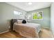 Light-filled bedroom with a patterned bedspread, green walls, and two windows offering natural light at 2990 S Jay St, Denver, CO 80227