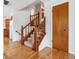View of the foyer with hardwood floors, a wooden staircase, and a convenient coat closet at 2990 S Jay St, Denver, CO 80227