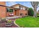 A welcoming front entrance featuring a brick exterior, garden beds, and a quaint bench at 2990 S Jay St, Denver, CO 80227