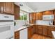 Traditional kitchen with wooden cabinets, white appliances, and a window overlooking the outdoor greenery at 2990 S Jay St, Denver, CO 80227