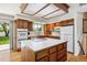 Well-lit kitchen featuring an island cooktop, white appliances, and ample cabinet space at 2990 S Jay St, Denver, CO 80227