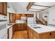 Functional kitchen featuring an island cooktop, wooden cabinets, and updated appliances at 2990 S Jay St, Denver, CO 80227