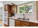 Traditional kitchen with wooden cabinets, stainless steel sink, and a window overlooking the outdoors at 2990 S Jay St, Denver, CO 80227