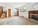 Open-concept living space with a brick fireplace, large window, and hardwood flooring at 2990 S Jay St, Denver, CO 80227