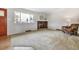 Bright living room featuring a brick fireplace, large window, and cozy armchair at 2990 S Jay St, Denver, CO 80227
