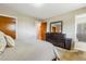 Spacious main bedroom featuring a dark wood dresser, mirror, and access to a closet and bathroom at 2990 S Jay St, Denver, CO 80227