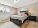 Cozy main bedroom with a dark wood bed frame, neutral-toned walls, and natural light from the windows at 2990 S Jay St, Denver, CO 80227