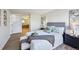 Bright bedroom with view to en suite bathroom and light wood-look flooring at 7680 Depew St # 1404, Arvada, CO 80003