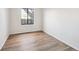 Bright bedroom featuring hardwood floors, white walls, and a window offering natural light at 7680 Depew St # 1404, Arvada, CO 80003
